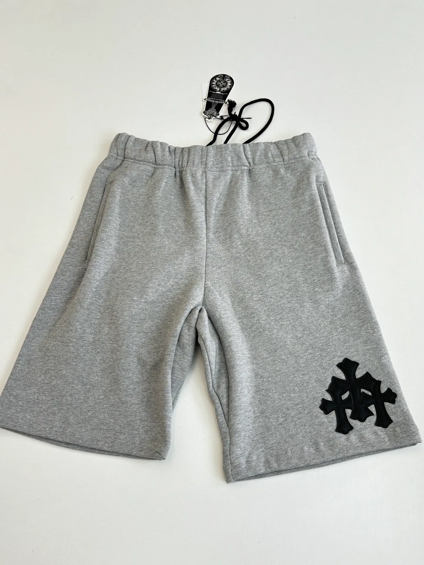P346 Chrome Hearts*/Chrome Hearts 26SS early spring new patch embroidered shorts The fabric is made of a blended ratio of 80% cotton and 20% polyester. It is woven with a siro spinning process of 32-count base yarn and 10-count veil to form a high-weight terry cloth base of 380g/㎡. The cotton-polyester blended material combines the skin-friendly breathability of cotton and the anti-wrinkle shape retention of polyester. The high-weight fabric gives the trousers excellent stiffness and drape. The core technology is patch embroidery, which is completed with the help of TAJIMA computer embroidery machine. The black special-shaped patch is precisely sewn to the trouser fabric through lock stitches. The embroidery stitch density is even and the edges are neatly hemmed, forming a three-dimensional relief-like visual effect. Size: S/M/L/XL
